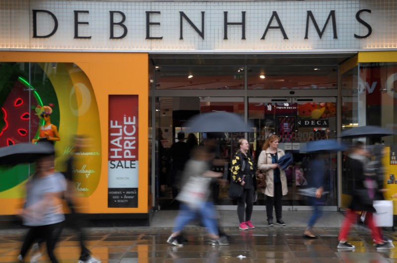© Reuters. Shoppers walk past a Debenham's store in central London