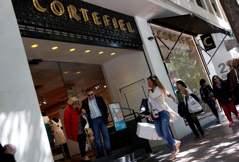 © Reuters. People walk out of a Cortefiel store in central Madrid
