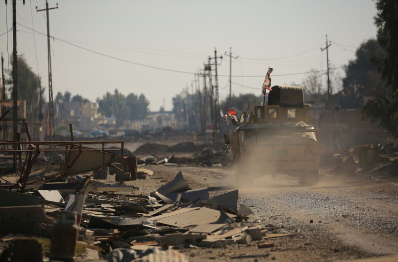 © Reuters. Iraqi army members ride in a military vehicle during a battle with Islamic State militants, in the village of Argoob