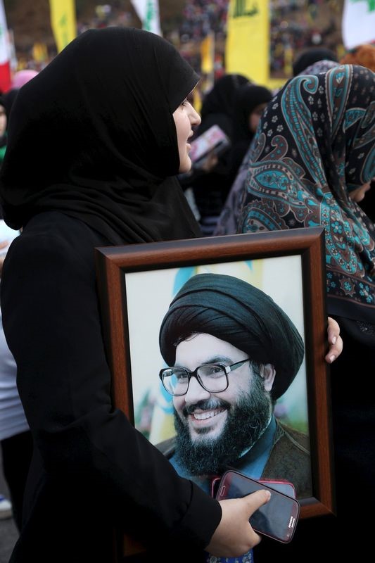 © Reuters. Mulher carrega foto de  líder do Hezbollah, Sayyed Hassan Nasrallah, durante 9º aniversário do fim da guerra com Israel, em Wadi al-Hujeir, sul do Líbano