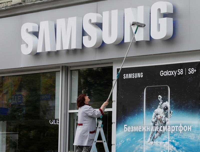 © Reuters. Funcionária limpa fachada de loja da Samsung em Kiev, Ucrânia