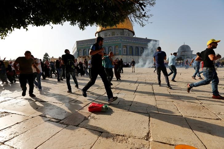 © Reuters. Palestinos reagem a granadas de atordoamento no complexo conhecido como Santuário Nobre pelos muçulmanos e Monte do Templo pelos judeus