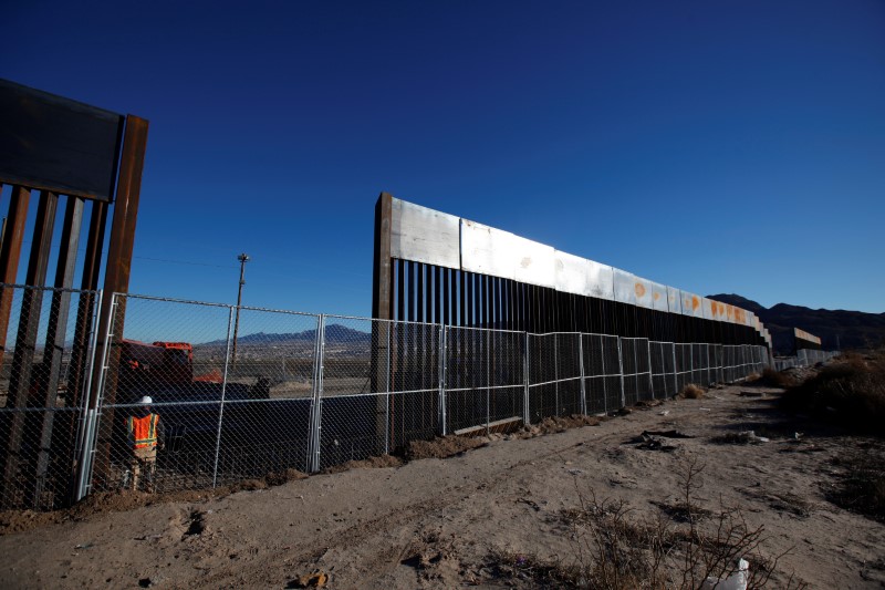 © Reuters. A worker stands next to a newly built section of the U.S.-Mexico border fence at Sunland Park, U.S. opposite the Mexican border city of Ciudad Juarez