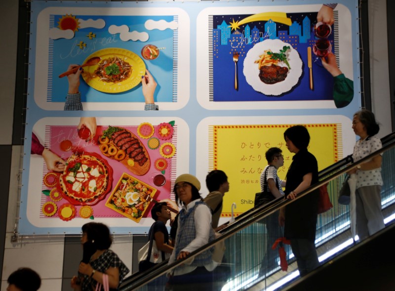 © Reuters. People on an escalator are seen in front of an advertisement board of a shopping mall in Tokyo