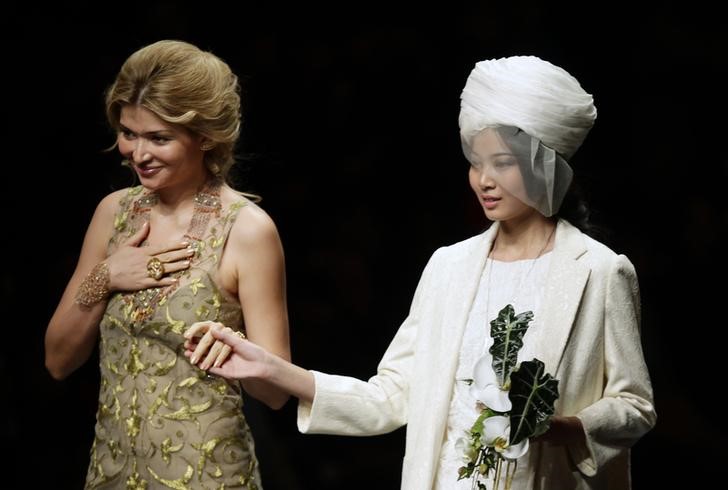 © Reuters. Designer Gulnara Karimova stands with a model after presenting her Guli Collection at China Fashion Week in Beijing