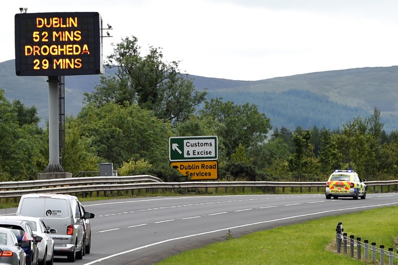 © Reuters. A police vehicle stops traffic beside a sign for customs and excise on the motorway approaching the border between Northern Ireland and Ireland, near Newry