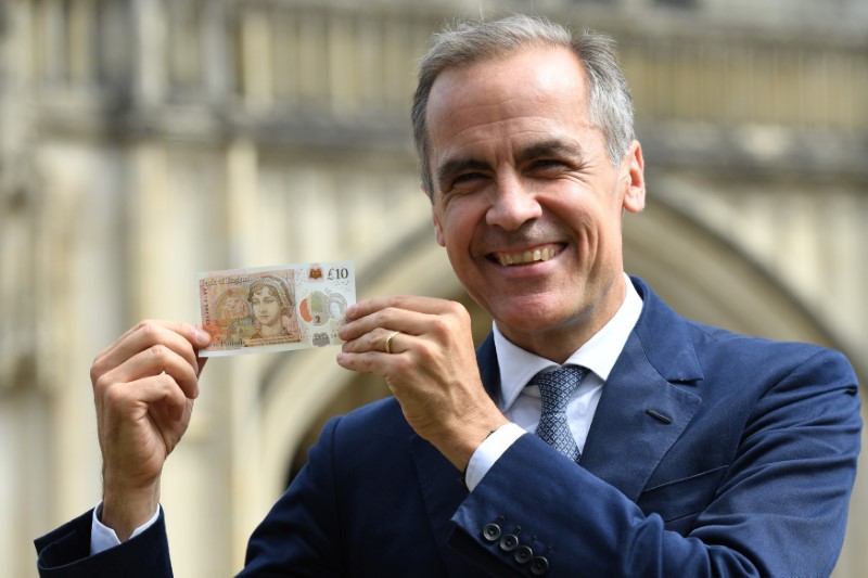 © Reuters. Britain's Bank of England Governor, Mark Carney, holds the new £10 note featuring Jane Austen, at Winchester Cathedral, in Winchester