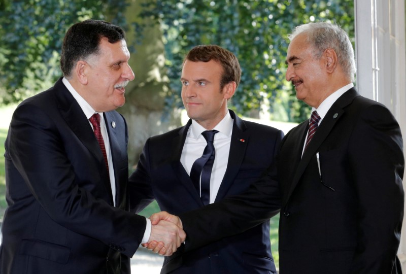 © Reuters. FILE PHOTO:French President Emmanuel Macron stands between Libyan Prime Minister Fayez al-Sarraj and General Khalifa Haftar, commander in the Libyan National Army (LNA), after talks in La Celle-Saint-Cloud near Paris