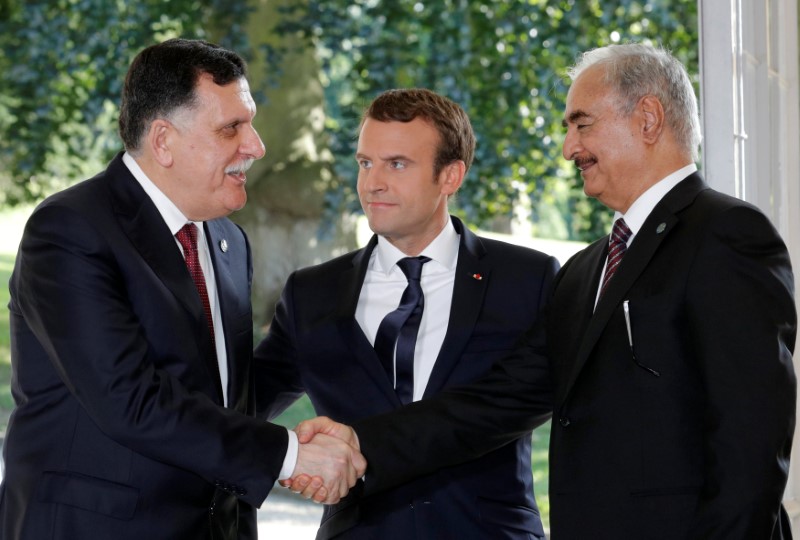 © Reuters. French President Emmanuel Macron stands between Libyan Prime Minister Fayez al-Sarraj and General Khalifa Haftar, commander in the Libyan National Army (LNA), after talks in La Celle-Saint-Cloud near Paris