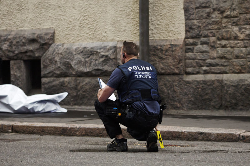 © Reuters. A police officer is seen at the scene of an accident in downtown Helsinki where an intoxicated man hit people with his car