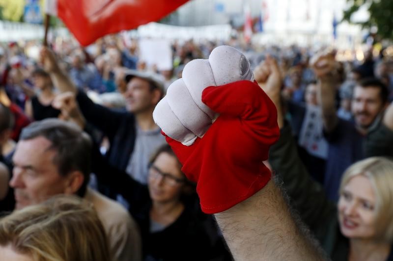© Reuters. People attend a protest against judicial reforms in front of the Law and Justice headquarters, in Warsaw