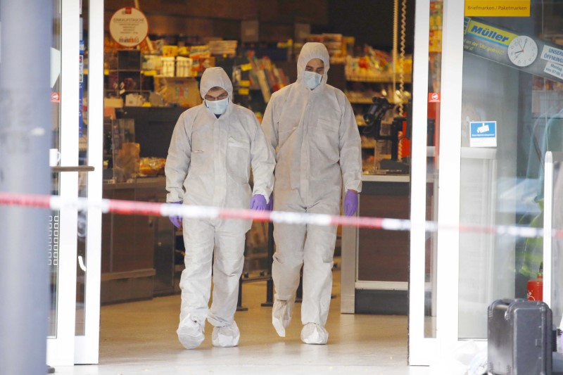 © Reuters. Police investigators work at the crime scene after a knife attack in a supermarket in Hamburg