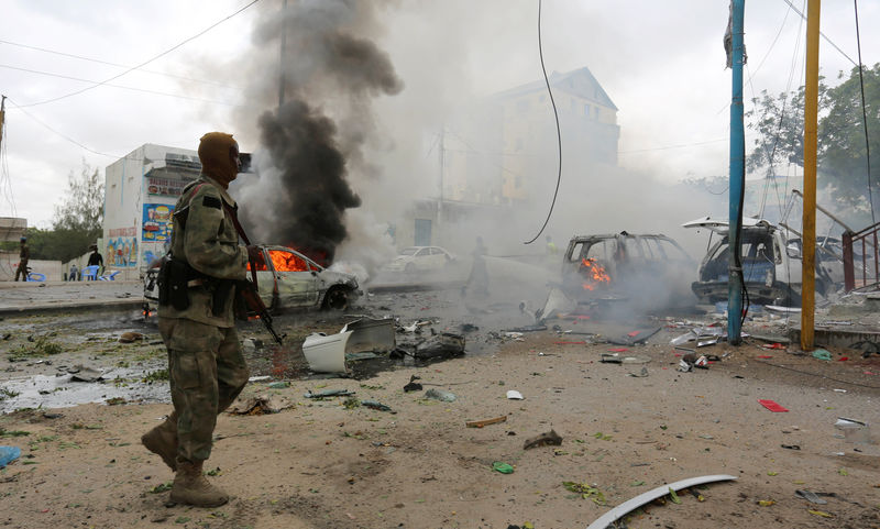 © Reuters. A Somali military officer secures the scene of an explosion in Maka al Mukaram road in Mogadishu