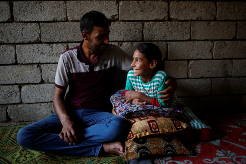 © Reuters. Nine-year-old Iraqi girl Meriam smiles as she looks at her father Hassan in a house east of Mosul