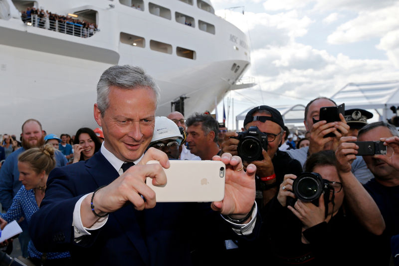 © Reuters. FILE PHOTO: French Economy minister Bruno Le Maire takes a picture of French President Emmanuel Macron near the MSC Meraviglia cruise ship during a visit to the STX Les Chantiers de l'Atlantique shipyard site in Saint-Nazaire