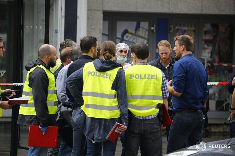 © Reuters. Police investigators work at the crime scene after a knife attack in a supermarket in Hamburg