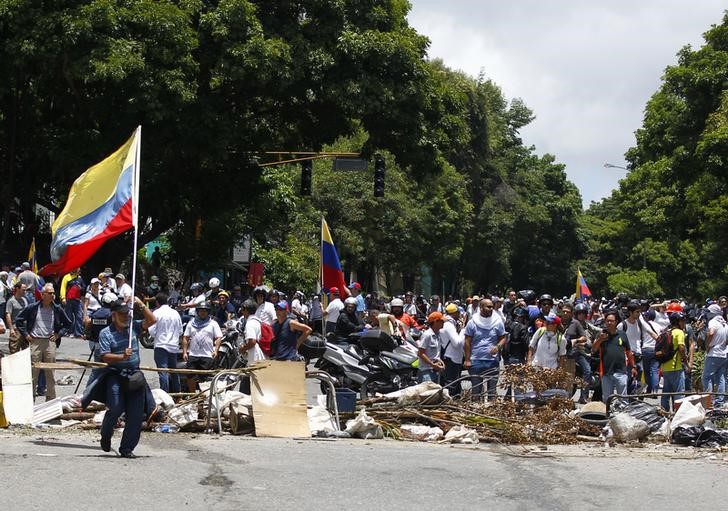 © Reuters. Opposition supporters stand near a barricade as clashes break out while the Constituent Assembly election is being carried out in Caracas