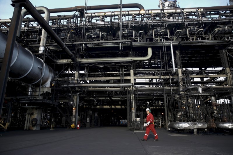 © Reuters. An oilfield worker walks next to pipelines at PDVSA's Jose Antonio Anzoategui industrial complex in the state of Anzoategui