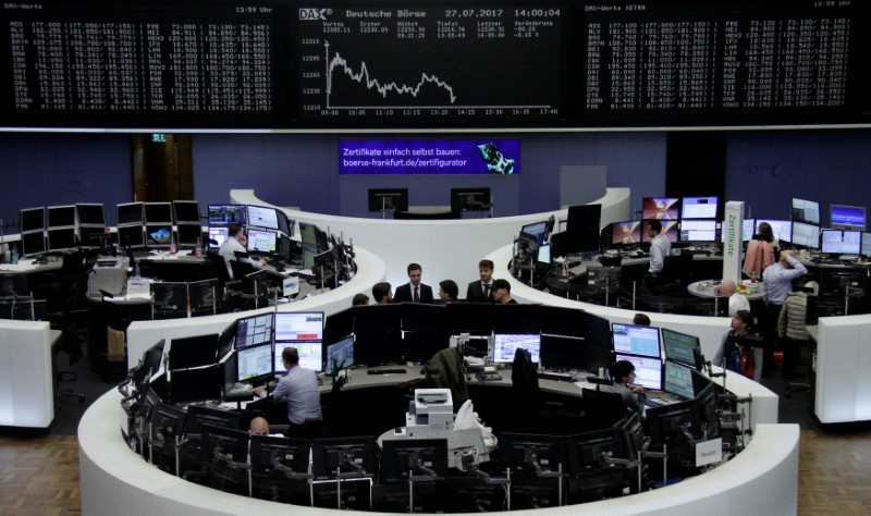 © Reuters. Traders work in front of the German share price index, DAX board, at the stock exchange in Frankfurt