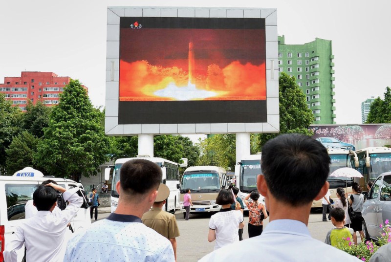 © Reuters. Pessoas observam reportagem sobre lançamento de míssil Hwasong-14 pela Coreia do Norte, na estação de Pyongyang