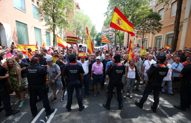 © Reuters. Mossos d'Esquadra officers (Catalan Regional Police) stand guard as Spanish Unionist protesters rally in front of Civil Guard headquarters in Barcelona