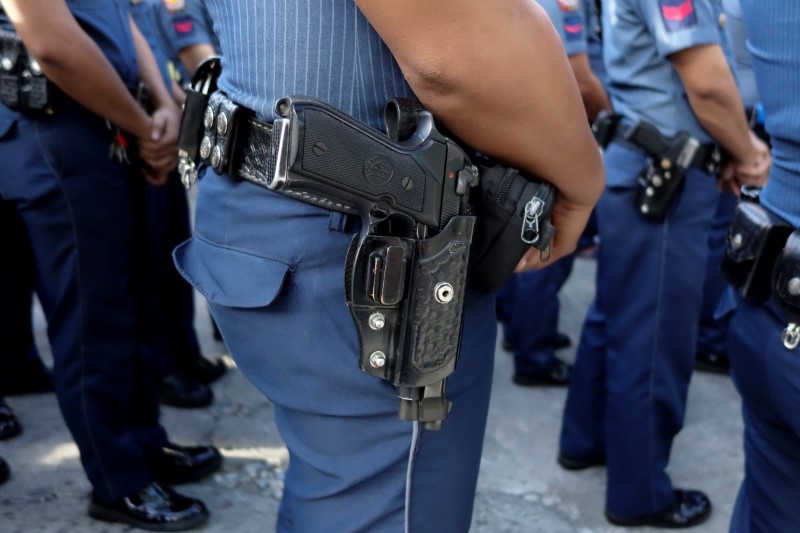 © Reuters. Police line up for a flag-raising ceremony outside a station in Quezon City Police District in Manila