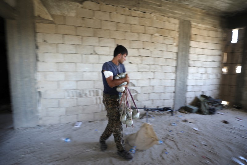 © Reuters. A fighter from Syrian Democratic Forces is seen carrying explosives in Raqqa