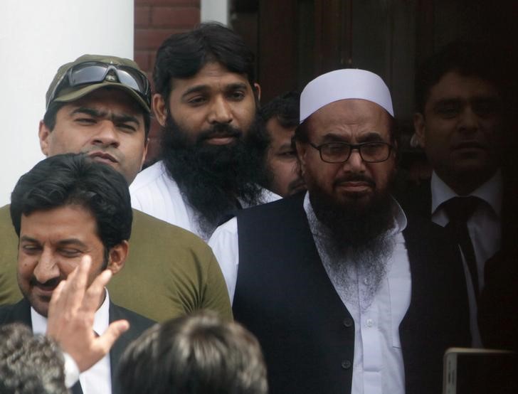 © Reuters. Hafiz Muhammad Saeed (R), chief of the Islamic charity organisation Jamaat-ud-Dawa (JuD), leaves after he appeared before a court to challenge his house arrest in Lahore