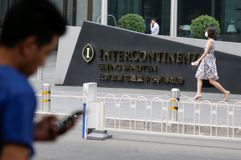 © Reuters. A man uses a phone outside the InterContinental hotel in Beijing