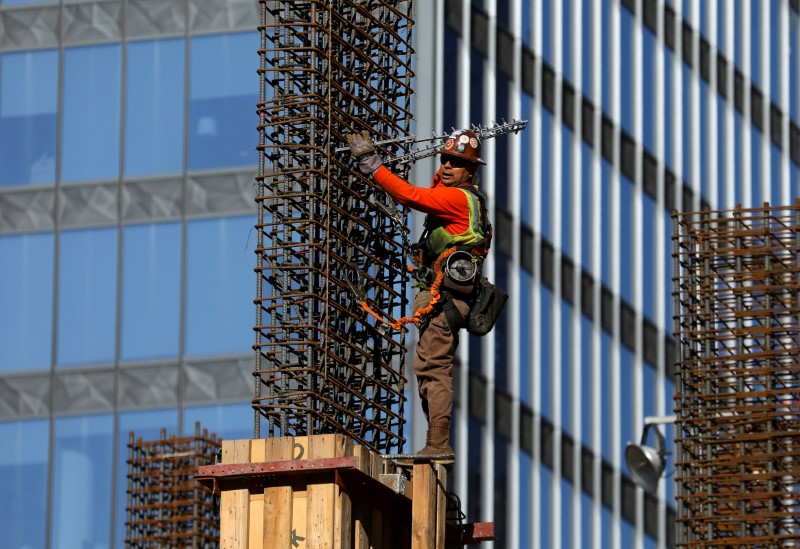 © Reuters. FILE PHOTO: A construction labourer works on top of a building in Los Angeles