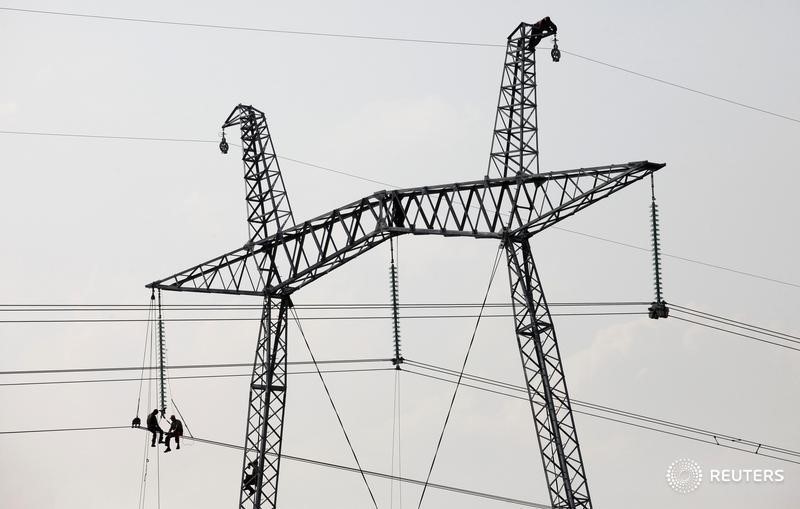 © Reuters. Рабочие на опоре ЛЭП у села Солёноозёрное в Хакасии