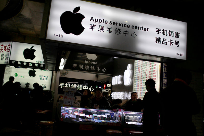 © Reuters. FILE PHOTO: Customers and sales persons are seen at an Apple maintenance service store at a mobile phone market in Shanghai