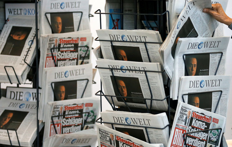 © Reuters. FILE PHOTO:A shareholder takes a newspaper during the annual shareholders meeting of German newspaper publisher Axel Springer in Berlin