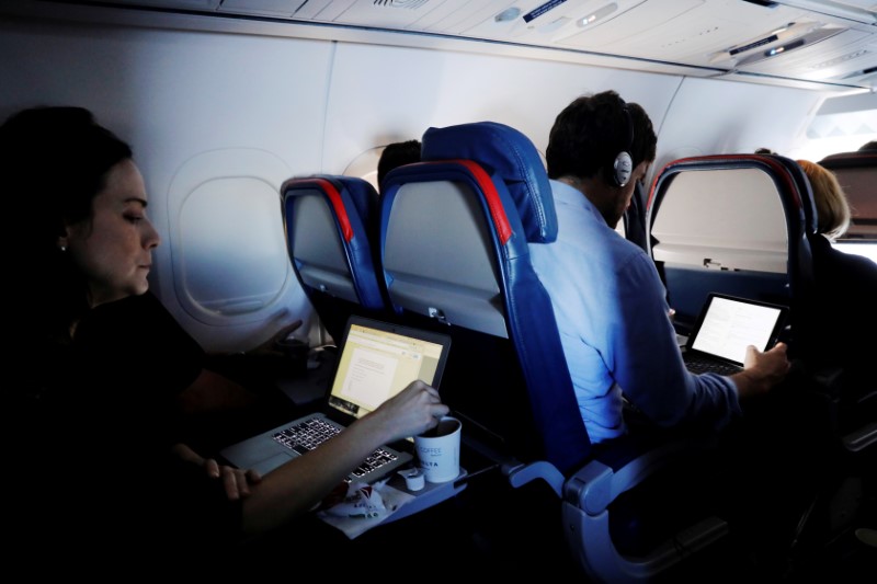 © Reuters. FILE PHOTO --  Passengers use their laptops on a flight out of JFK International Airport in New York