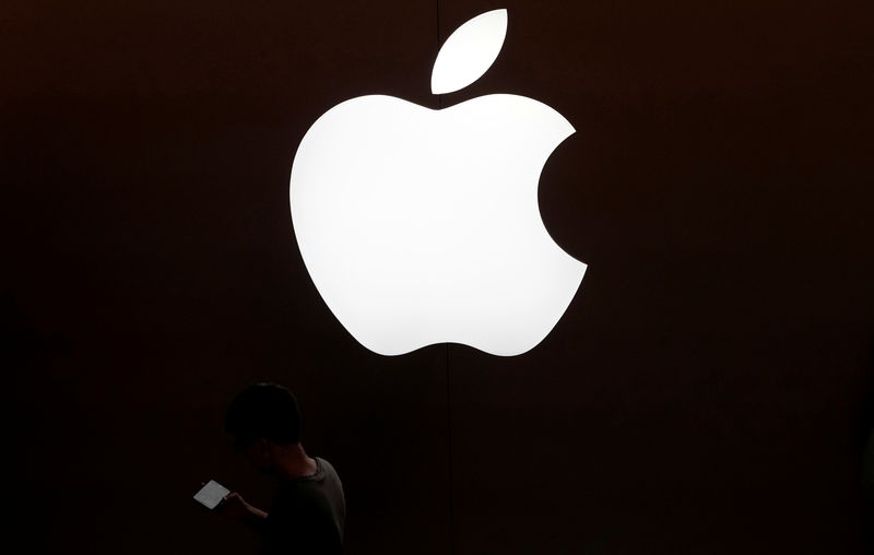© Reuters. Homem usa celular em frente a loja da Apple em Xangai, China