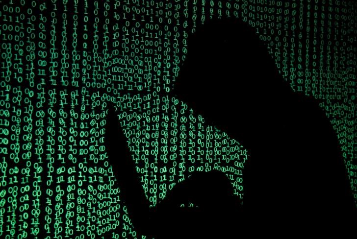 © Reuters. Homem utiliza computador diante de projeção de códigos cibernéticos