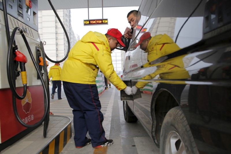 © Reuters. A gas station attendant pumps fuel into a customer's car at PetroChina's petrol station in Beijing