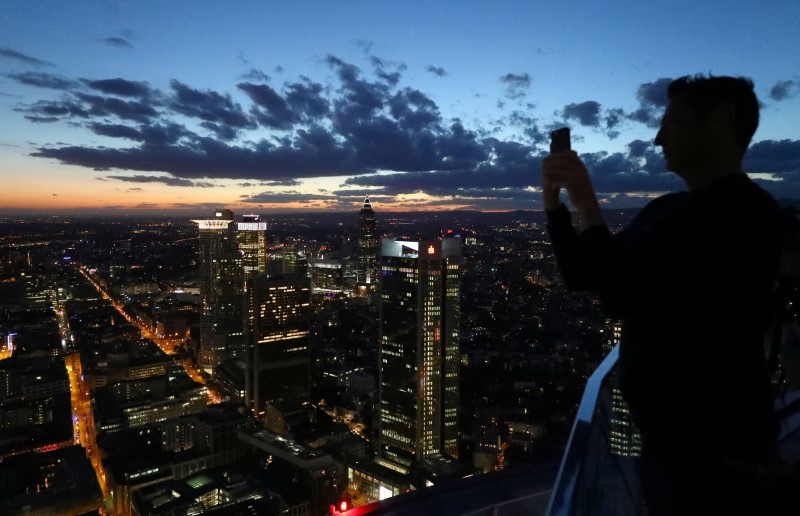 © Reuters. FILE PHOTO: A visitor of a skyscraper observation platform takes a picture of Frankfurt's skyline