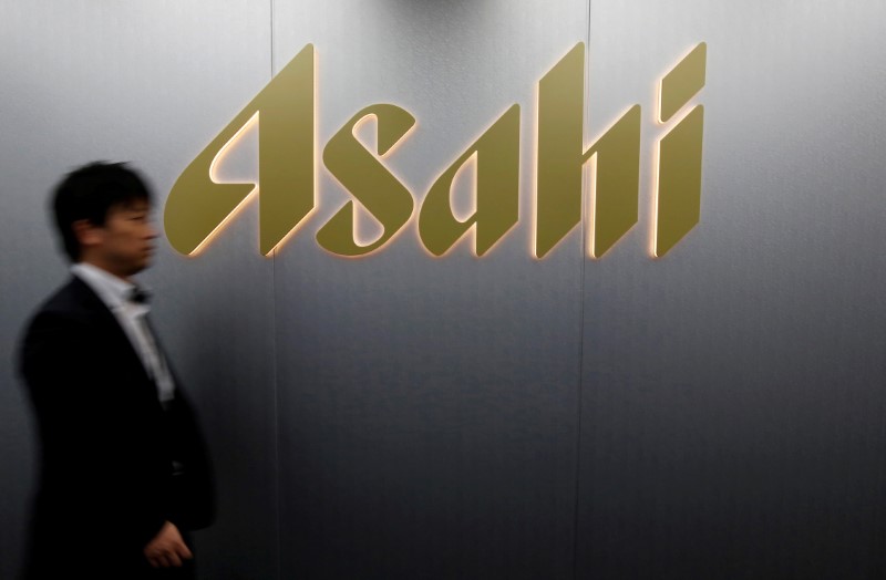 © Reuters. FILE PHOTO: Man walks past the logo of Asahi Group Holdings at the company's headquarters in Tokyo