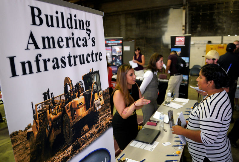 © Reuters. A recruiter talks with a job seeker at the Construction Careers Now! hiring event in Denver