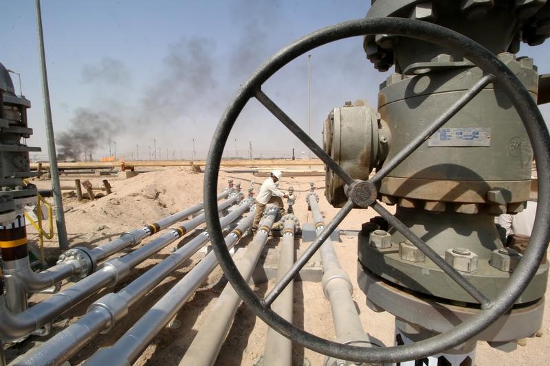 © Reuters. Trabalhador ajusta válvula de oleoduto no campo de Zubair, em Basra, Iraque