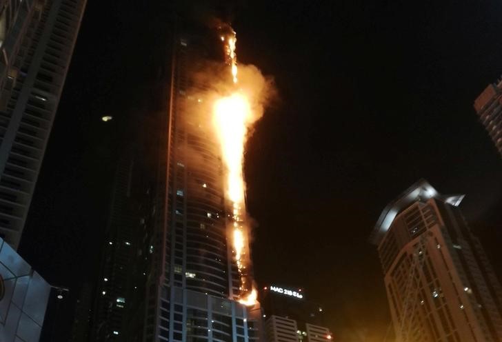 © Reuters. إخماد حريق بمبنى سكني شاهق في دبي