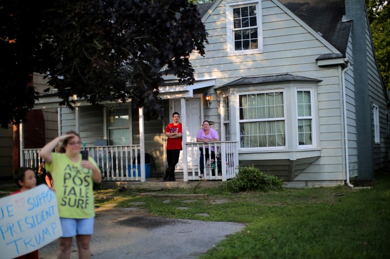 © Reuters. Local residents look at a motorcade transporting U.S. President Donald Trump to a rally, in Huntington, West Virginia