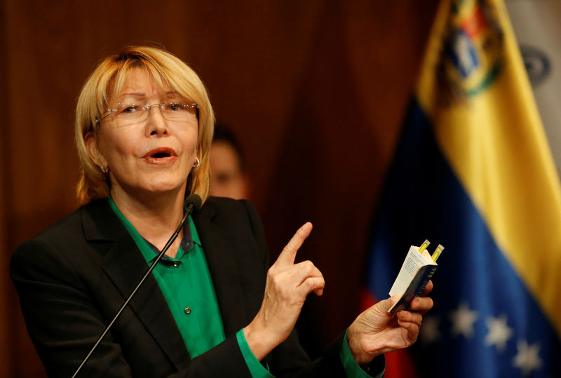 © Reuters. Venezuela's chief prosecutor Luisa Ortega Diaz holds a Venezuelan constitution during a news conference in Caracas