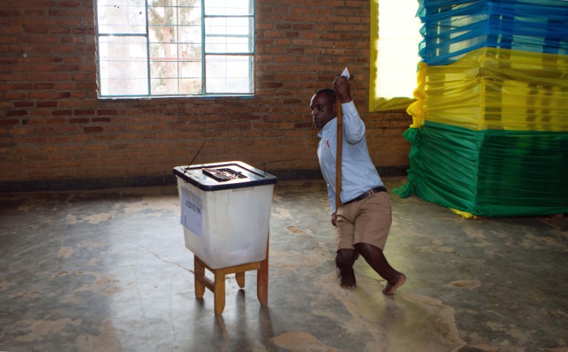 © Reuters. A disabled man prepares to cast his vote at a polling station in Kigali