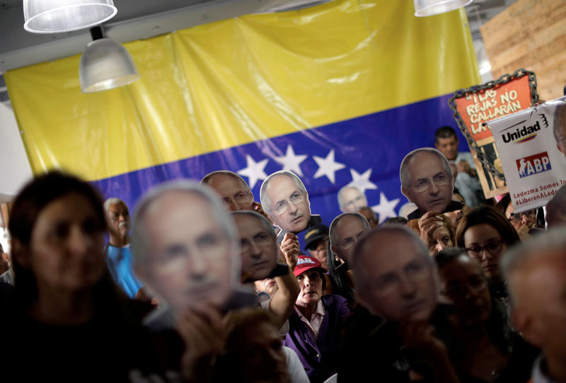 © Reuters. Pessoas seguram retratos do líder de oposição venezuelano Antonio Ledezma, em Caracas