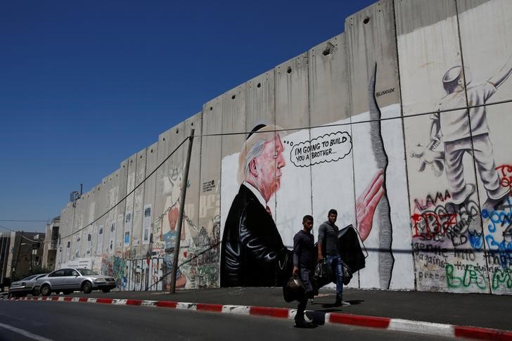© Reuters. جرافيتي في بيت لحم يظهر ترامب وهو يعانق الجدار العازل