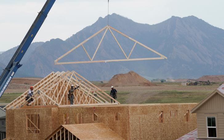 © Reuters. Workers install roof trusses onto a new house in Arvada