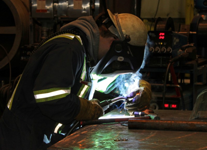 © Reuters. A worker uses a welding torch at Champion Iron's Bloom Lake mine near Fermont