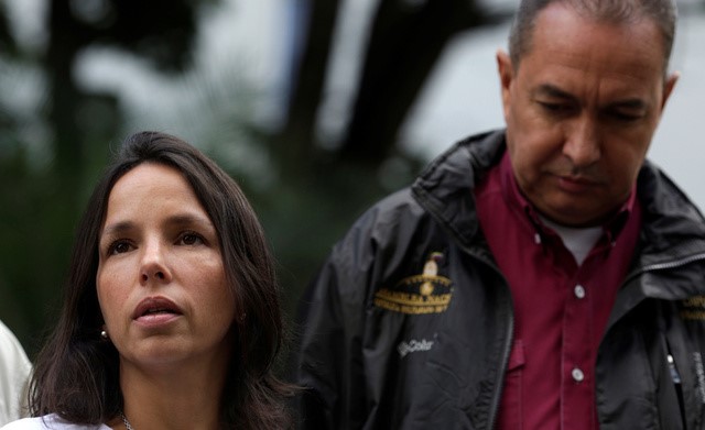 © Reuters. Oriette Schadendorf Capriles, stepdaughter of opposition leader Antonio Ledezma, is accompanied by lawmaker Richard Blanco as she talks to reporters outside their home in Caracas